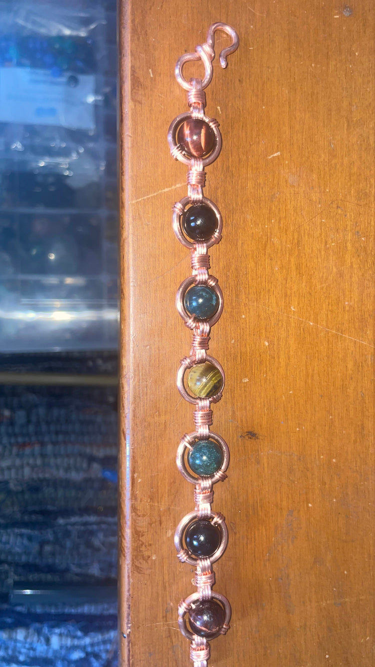This is my hand-wrapped copper bracelet with Red Tigers Eye (10mm), Silver Sheen Obsidian (10mm), Green Moss Agate and Golden Tigers Eye with handmade links. 